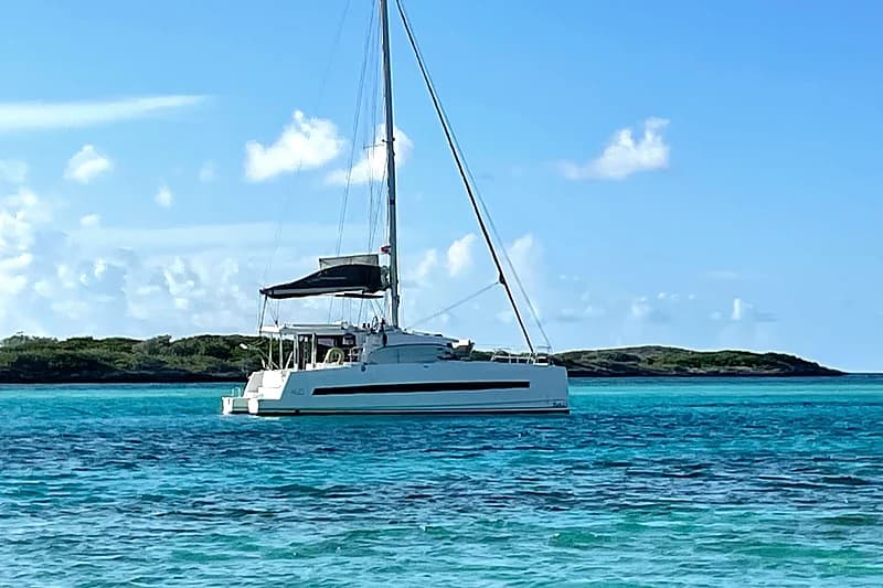 Exumas — a catamaran at anchor in turquoise water with a low cay behind