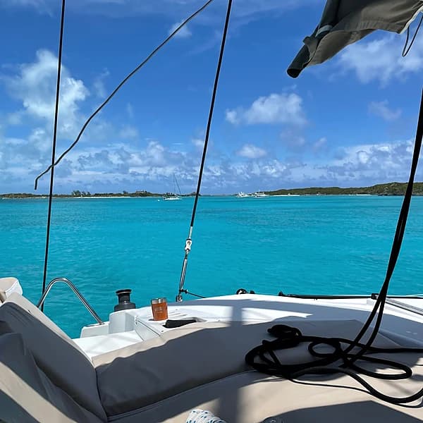 Dinghy heading ashore at a calm Exumas anchorage in clear turquoise water