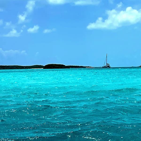 Late-afternoon light on an Exumas anchorage, low cays on the horizon